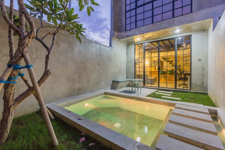 Modern courtyard with small pool and glass doors.