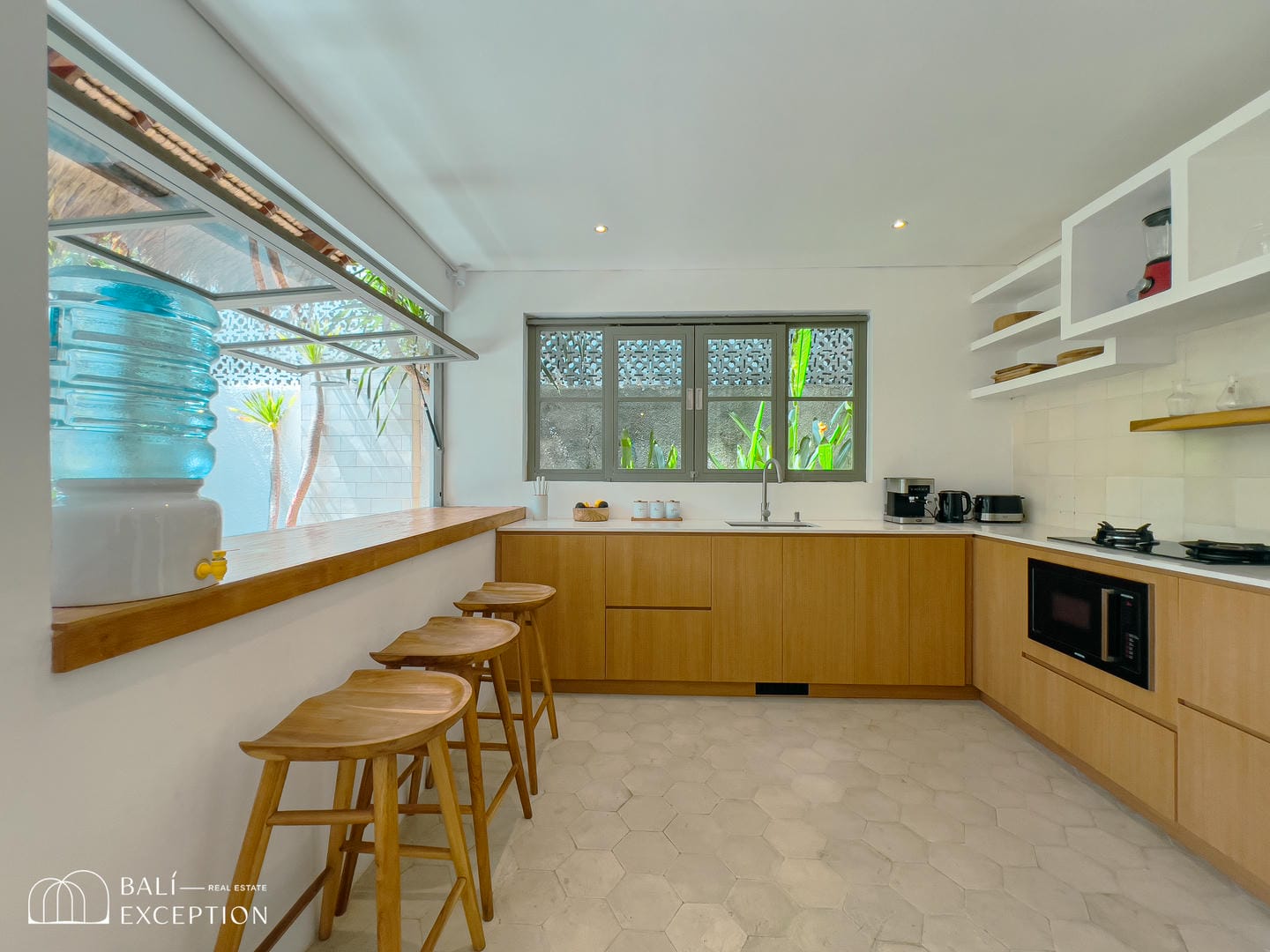 Modern kitchen with wooden bar and stools.