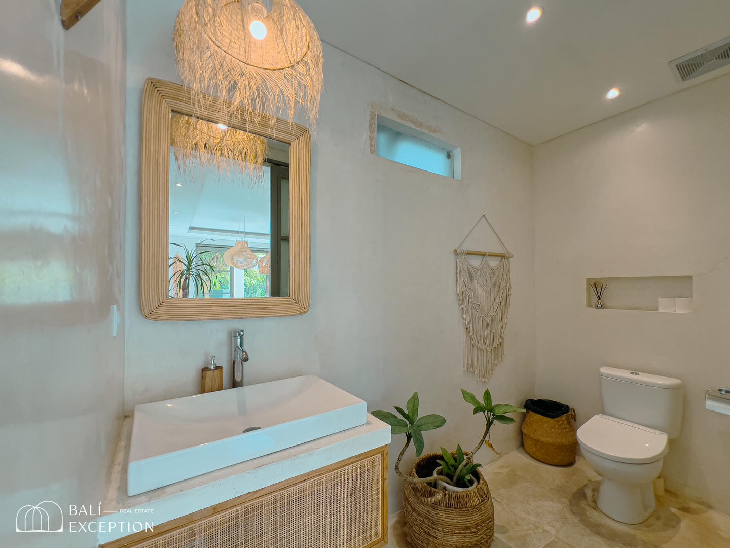 Modern bathroom with plants and wicker decor.