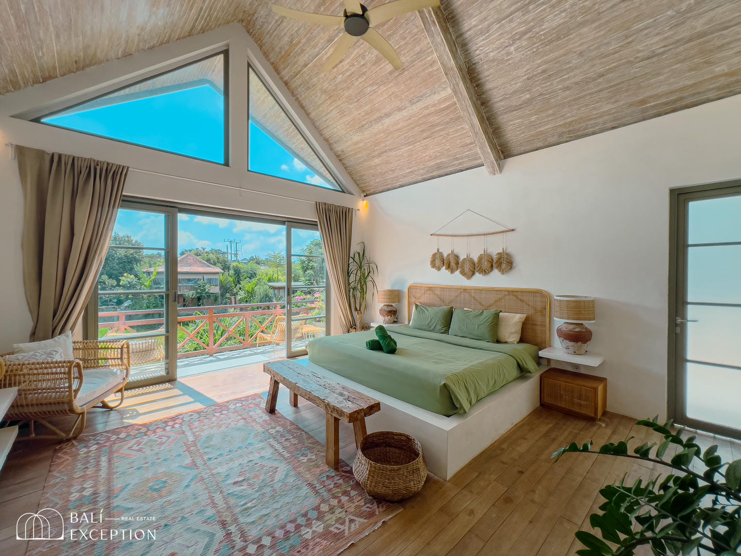 Spacious bedroom with balcony and natural decor.