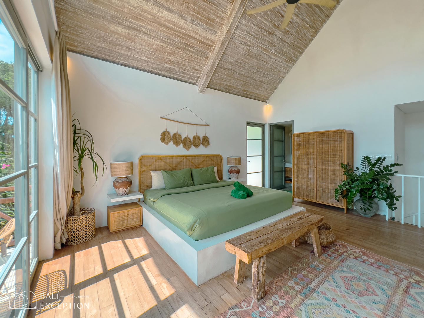 Cozy bedroom with green bed and wooden decor.
