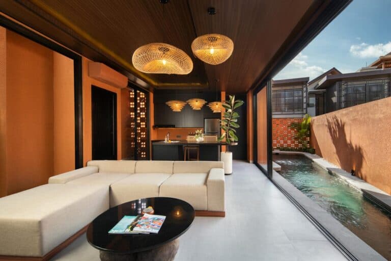 Modern living room with pool and kitchen view.