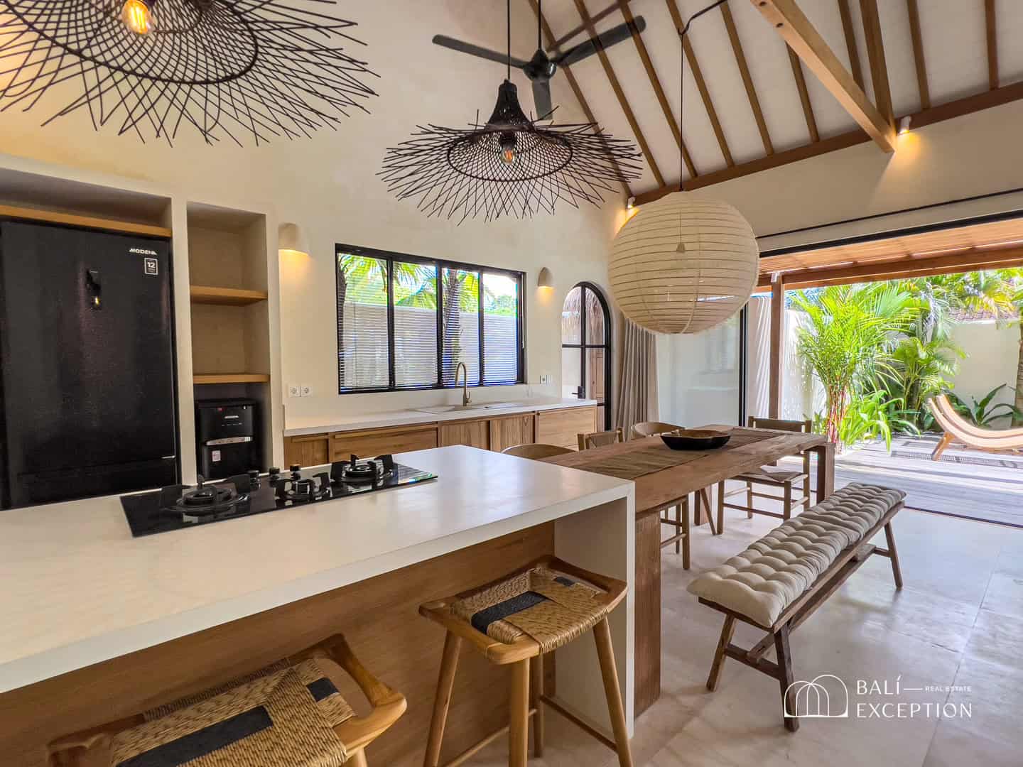 Modern kitchen and dining area with tropical view.