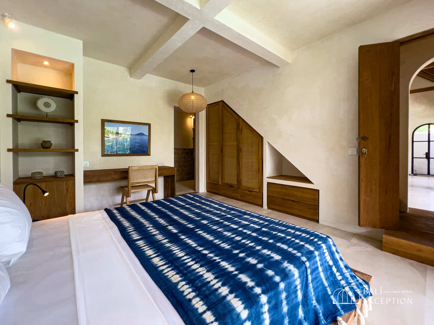 Modern bedroom with wooden furniture and blue bedspread
