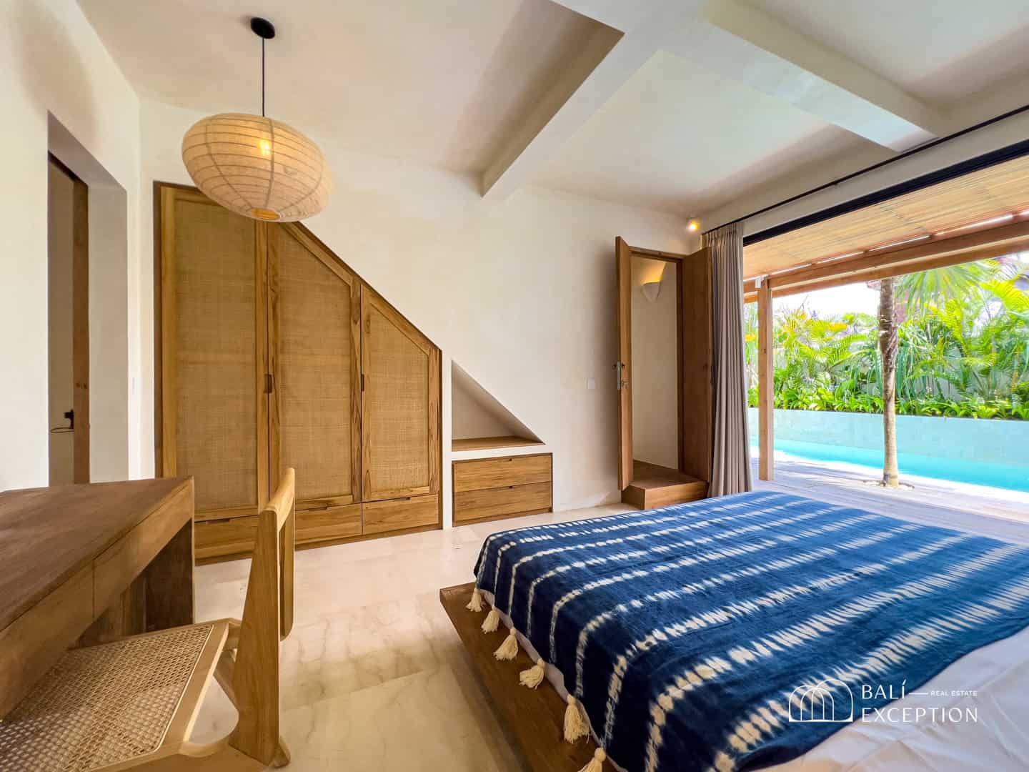Luxury villa bedroom with pool view.