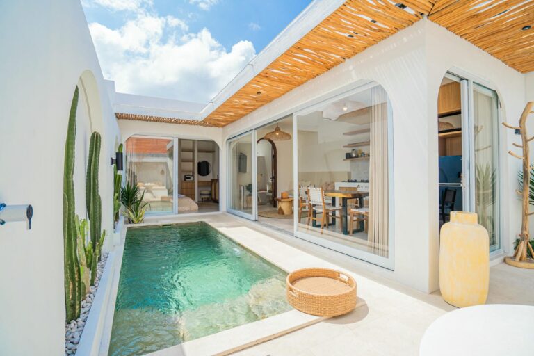 Modern villa with pool and outdoor dining area.