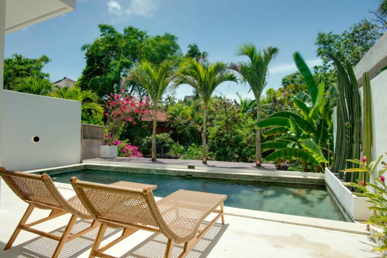 Tropical garden view with pool and lounge chairs.