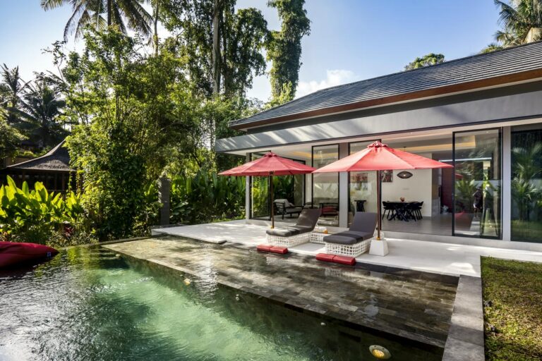 Modern house with pool and lounge chairs.