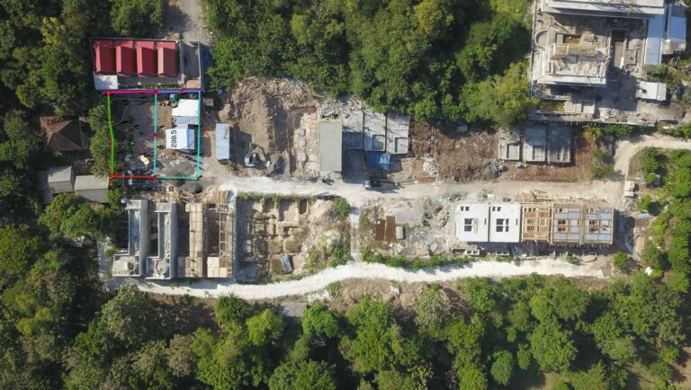 Aerial view of construction site surrounded by trees.