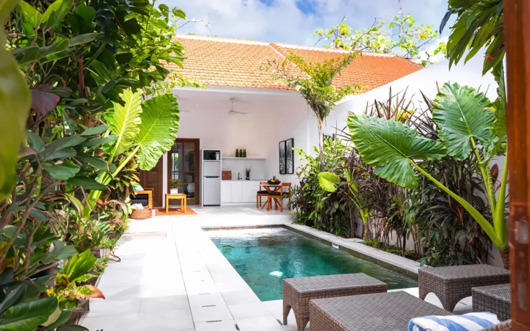 Tropical courtyard with pool and open dining area.