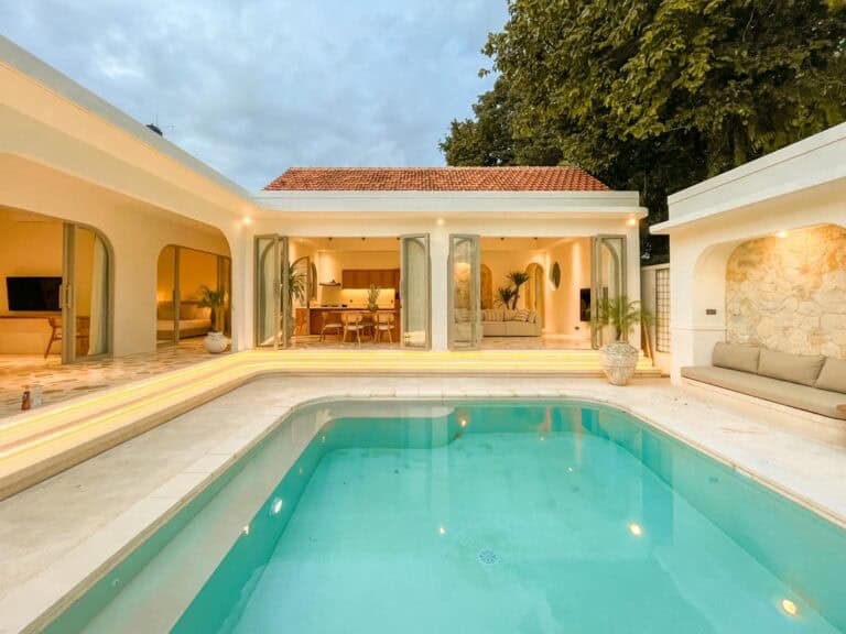 Modern house with patio and pool at dusk.