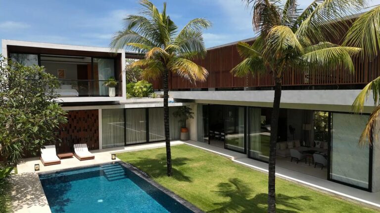 Modern villa with pool and palm trees.