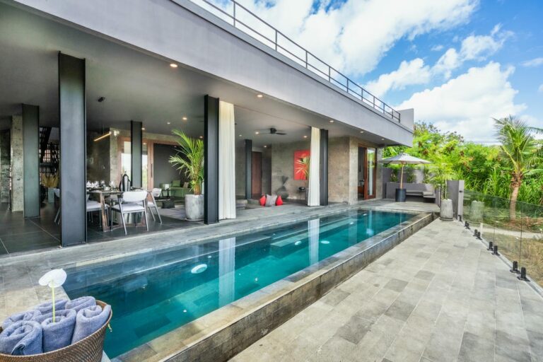Modern villa with pool and outdoor dining area.