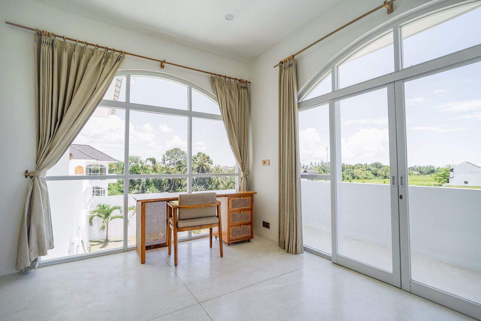 Bright room with large windows and desk view.