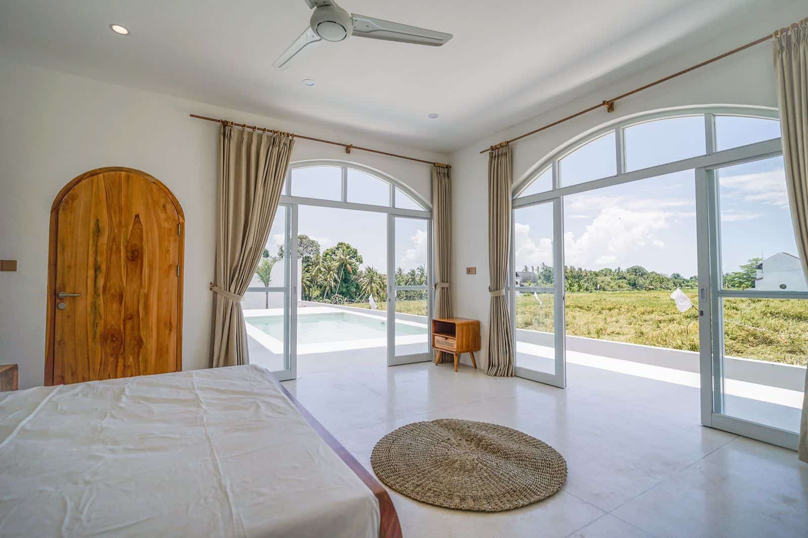 Bright bedroom with windows and pool view