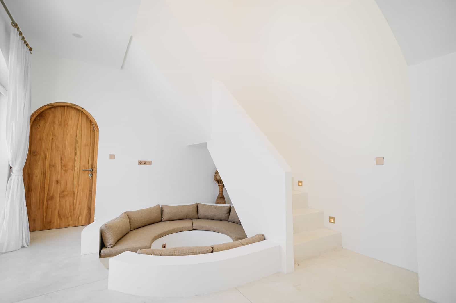 Minimalist room with round seating and staircase