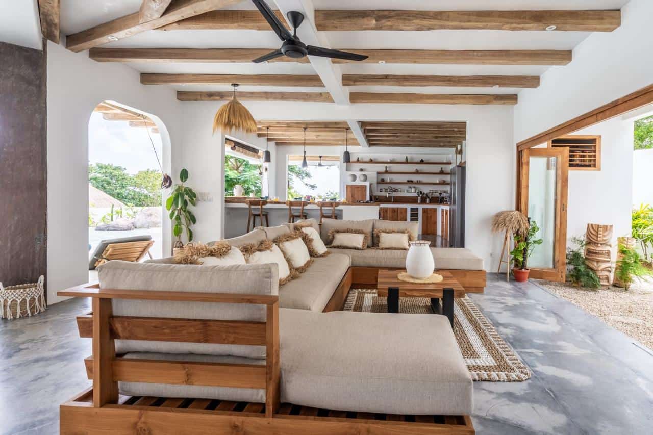 Modern living room with wooden accents and open kitchen.