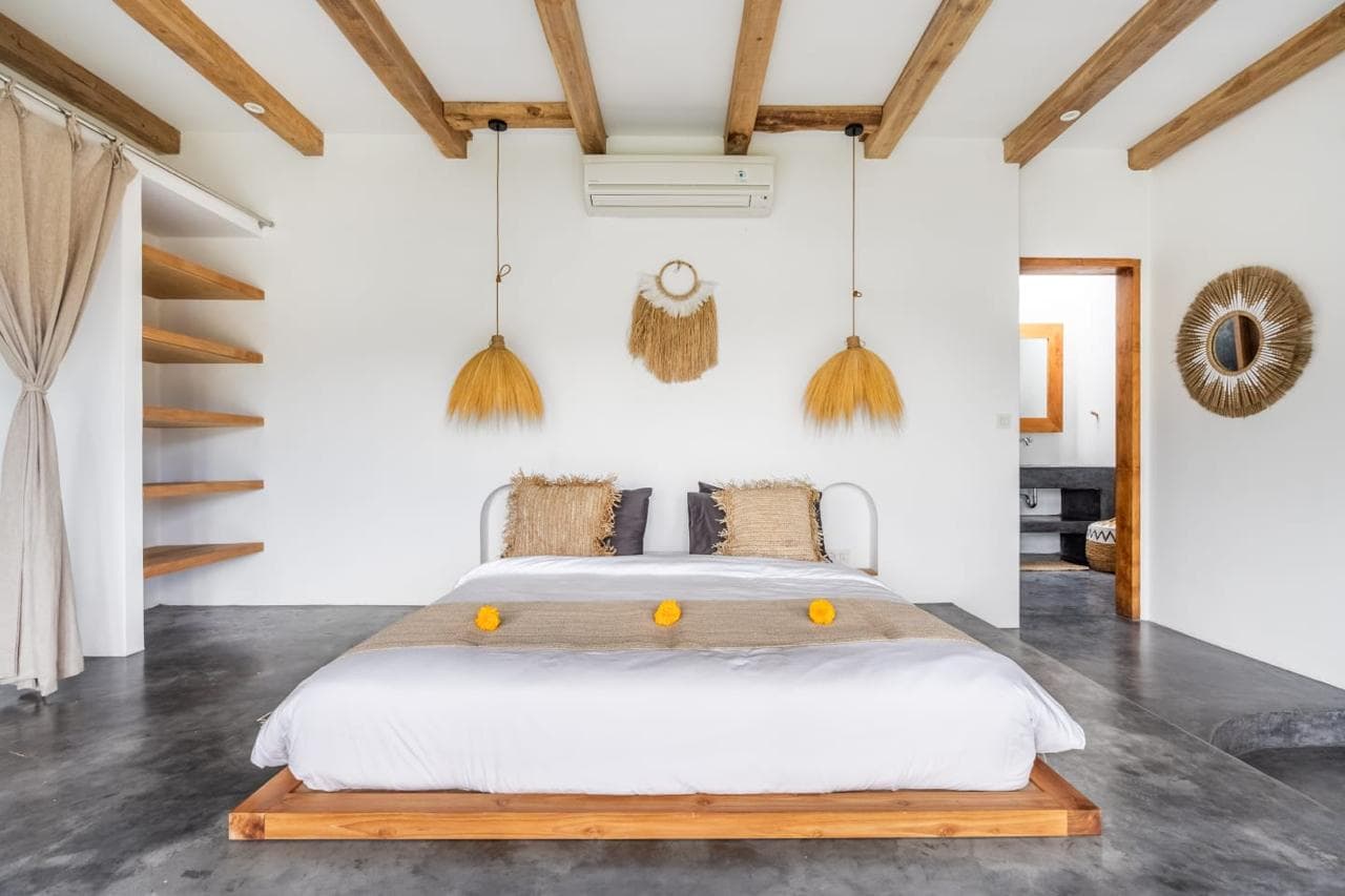 Minimalistic bedroom with wooden beams and decor.
