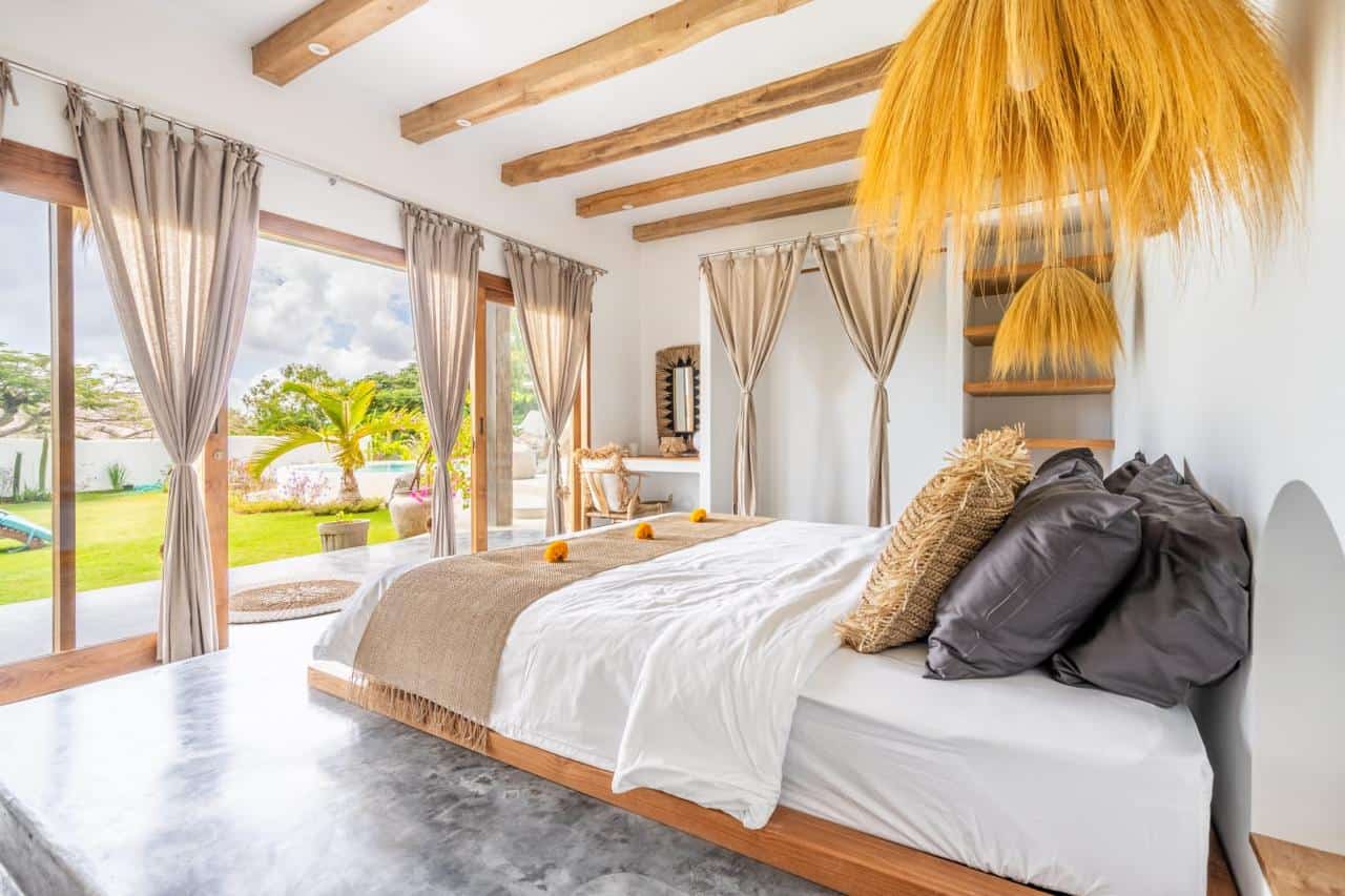 Modern bedroom with large windows and garden view.