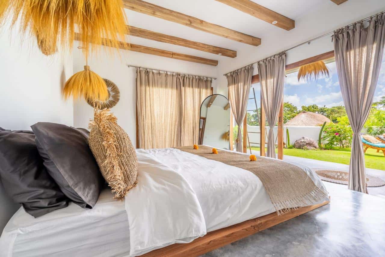 Bright bedroom with canopy bed and garden view.