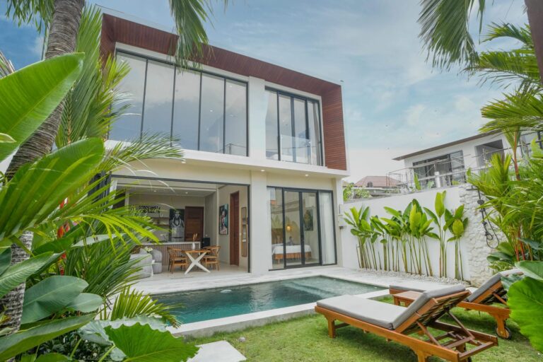 Modern villa with pool and lush garden view.