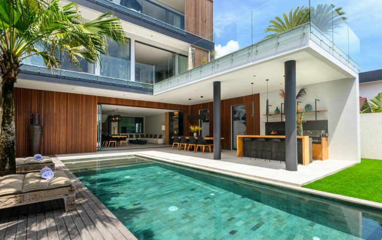 Modern house with pool and outdoor dining area.