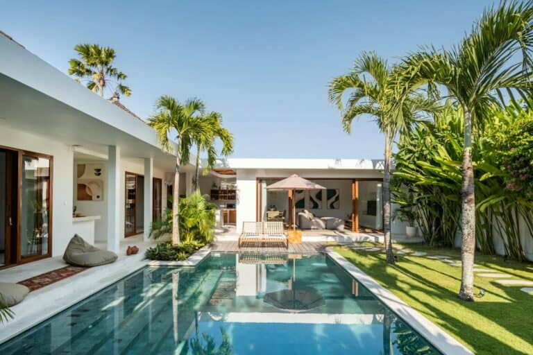 Modern villa with pool and palm trees.