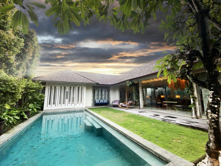 Modern villa with swimming pool at sunset.