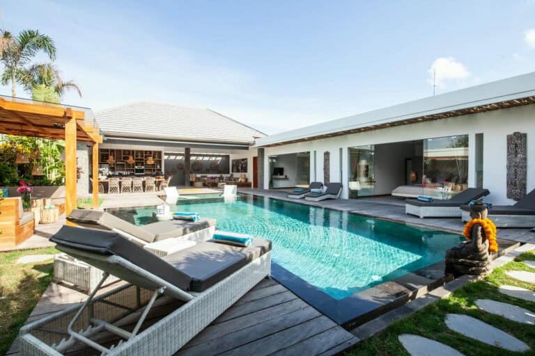 Luxurious villa with pool and sun loungers.