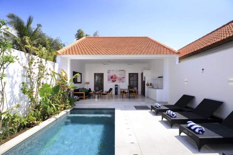 Modern villa patio with pool and lounge chairs.