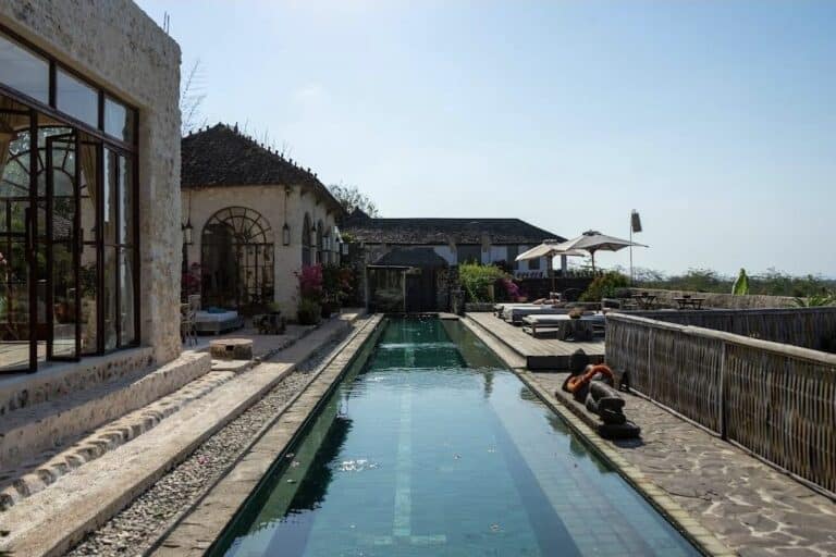 Tranquil villa courtyard with pool and seating area.
