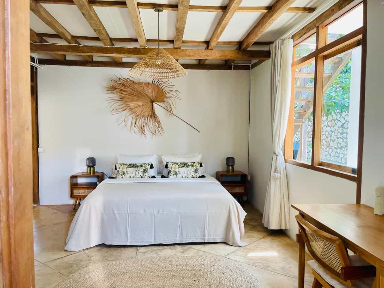 Modern bedroom with wood accents and large window.