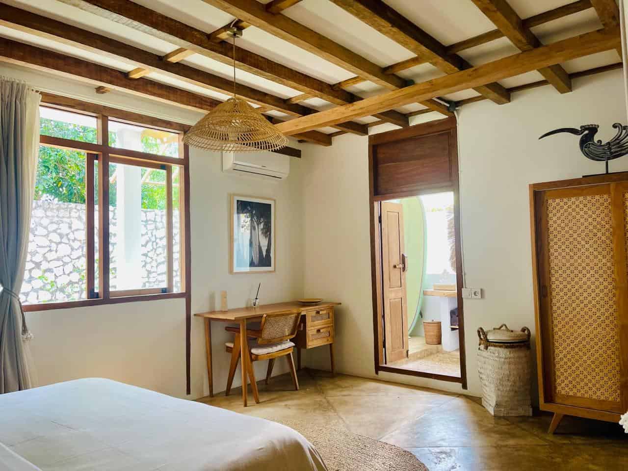 Cozy bedroom with wooden decor and large window.