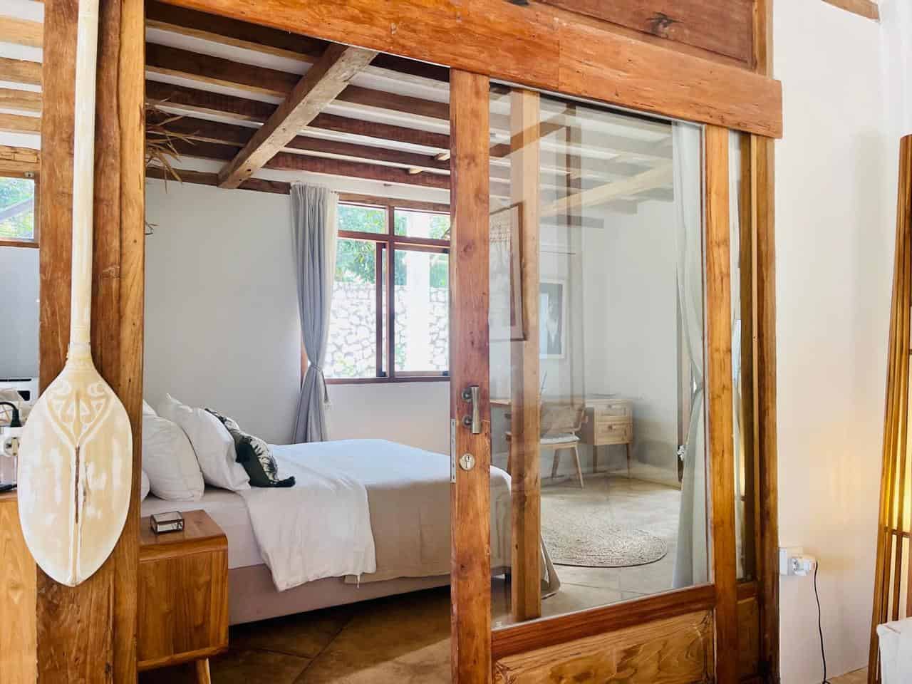 Cozy rustic bedroom with wooden decor and large window.