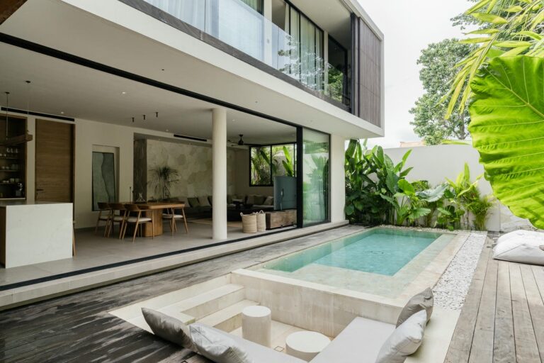 Modern house with pool and lush greenery.