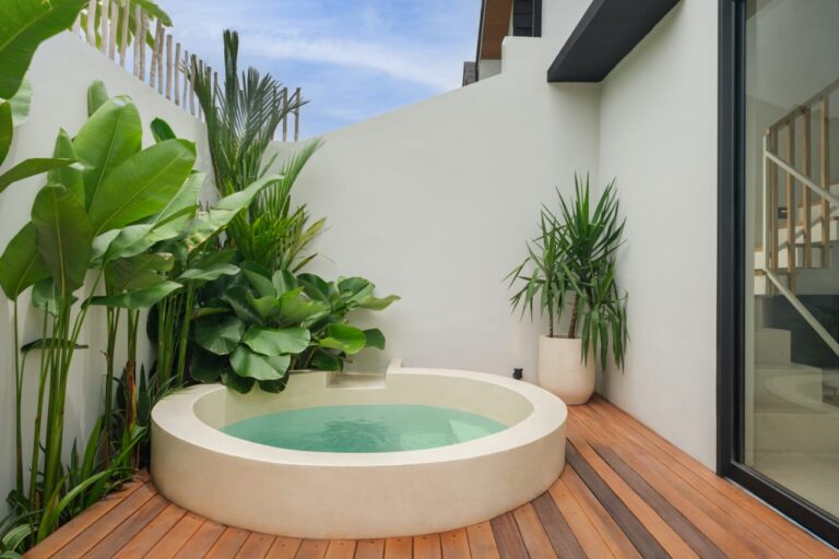 Small garden with round pool on wooden deck.