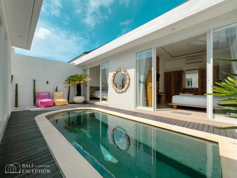 Modern villa with pool and lounge chairs outside.