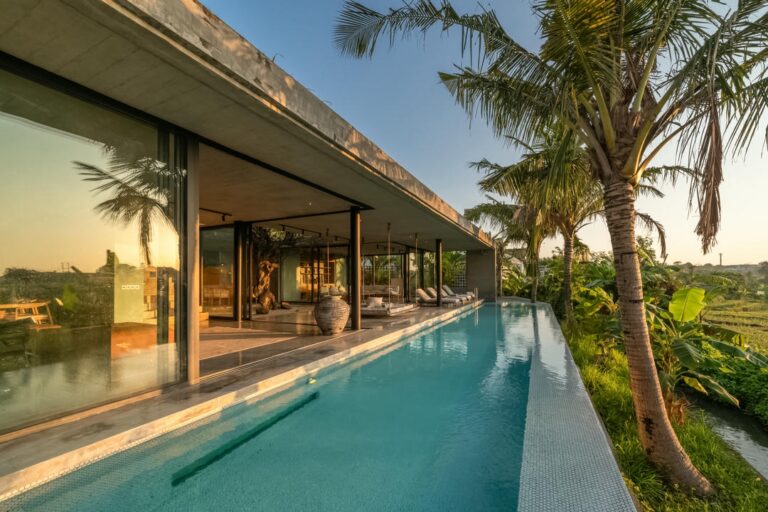 Luxury villa with infinity pool at sunset.