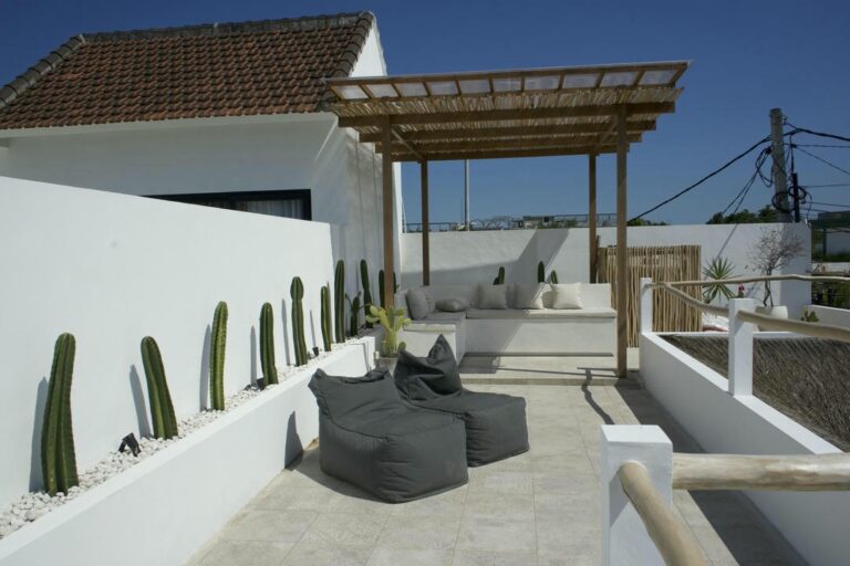 Rooftop patio with cacti and seating area.