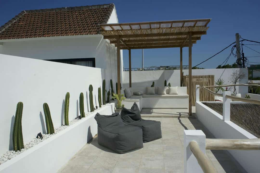 Rooftop patio with cacti and seating area.