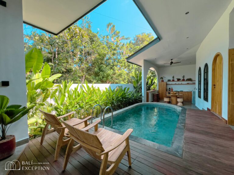 Cozy outdoor pool area with wooden chairs.
