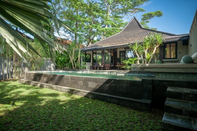 Tropical villa with pool and lush greenery.