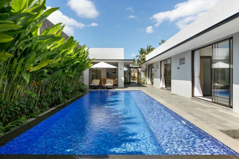 Modern villa with pool and tropical plants.