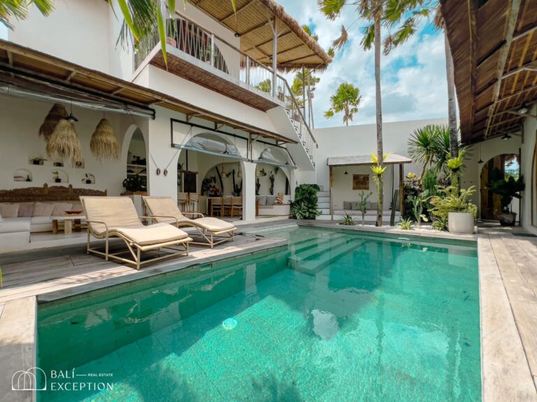 Luxury villa with pool and tropical plants.