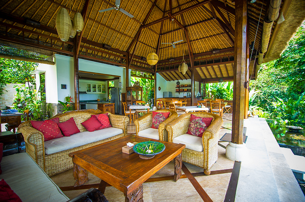 Open-air tropical living room with wicker furniture.